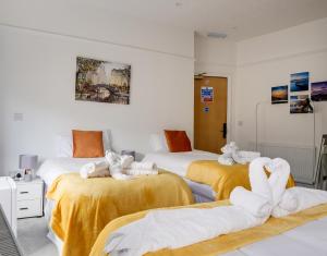2 camas con toallas en una habitación en Homesly Guest Rooms, Comfortable En-suite Guest Rooms with Free Parking and Self Check-in, en Berwick-Upon-Tweed