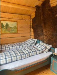 a bed in a log cabin with a painting on the wall at Hytte på idyllisk seter in Fosset