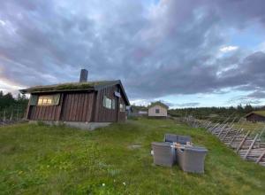 a small house with two trash cans in front of it at Hytte på idyllisk seter in Fosset