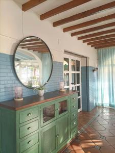 baño con tocador verde y espejo en Hotel Carmen, en La Carlota