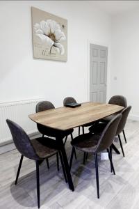a wooden table and chairs in a room at West Lake District Comfort Stays in Maryport town centre in Maryport