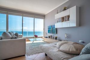 ein Wohnzimmer mit einem Sofa und Meerblick in der Unterkunft Front beach Apartment in Paul do mar 9 in Paul do Mar