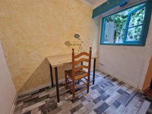 una mesa y una silla en una habitación con ventana en Casa con terraza a 10min de la playa, en Cullera