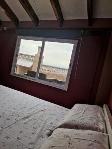 a bedroom with a bed and a window at Casa con terraza a 10min de la playa in Cullera