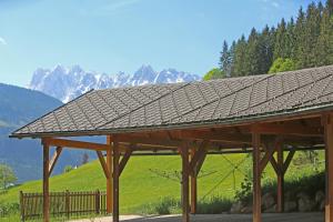 a wooden pavilion with a mountain in the background at Appartementhaus Wehrenfennig in Gosau
