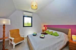 a bedroom with a large bed and a chair at GITE DE 6 A 14 PERSONNES Chez Léontine in Lacave