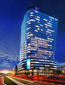 a tall building at night with traffic in front of it at Hanza Tower - SCANDIA Apartment, 16 Floor, Sunset View in Szczecin