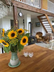 een vaas gevuld met zonnebloemen zittend op een tafel bij Blomstertantens Hus in Trelleborg