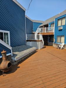 a large deck with a blue building with a vase on it at Knights Inn Mackinaw City in Mackinaw City