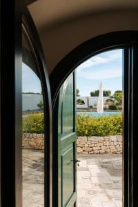 an open door with a view of a pool at Masseria Gorgognolo in Ostuni