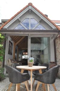 un patio con mesa y sillas frente a un salón acristalado en Vakantiehuis 't Verloren Schaap Damme, en Damme