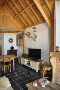 a living room with a flat screen tv and a table at Vakantiehuis 't Verloren Schaap Damme in Damme