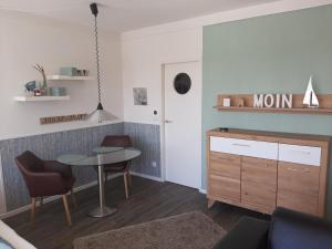 Habitación con mesa, sillas y comedor. en Penthouse Ferienwohnung Auszeit, gerne mit Hund, WLAN inkl., en Laboe