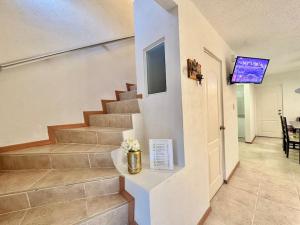 eine Treppe in einem Haus mit einem TV an der Wand in der Unterkunft Acogedora casa en Morelos in Tezoyuca