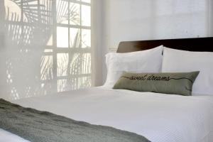ein weißes Bett mit einem Kissen und einem Fenster in der Unterkunft Acogedora casa en Morelos in Tezoyuca