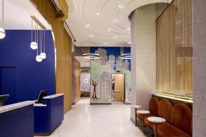 a lobby with blue walls and orange chairs at Delta Hotels by Marriott New York Times Square in New York