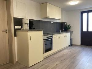 a kitchen with white cabinets and a stove top oven at Apartment Mate Wohnung 2 in Stobreč