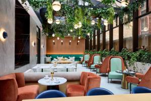 un restaurant avec des tables, des chaises et des plantes dans l'établissement Delta Hotels by Marriott New York Times Square, à New York