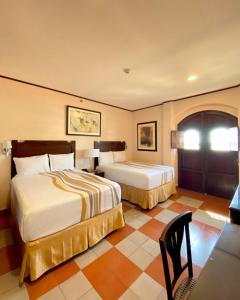 a hotel room with two beds and a table at Hotel La Recolecci&oacute;n in Le&oacute;n