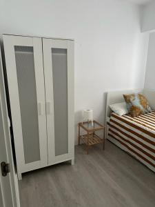 - une chambre avec un lit et une armoire blanche dans l'établissement Ameyal Madre Rafols, à Séville