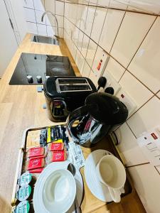 a kitchen counter with a table with plates and a toaster at Premium Studio Flat 02 Near Tower Bridge in London