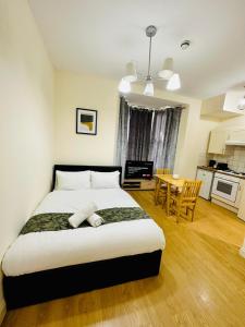 a bedroom with a large bed and a kitchen at Premium Studio Flat 02 Near Tower Bridge in London