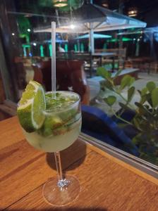 una bebida con una rodaja de limón en un vaso sobre una mesa en Recanto Taperapuan Residencial Mont Carmelo en Porto Seguro