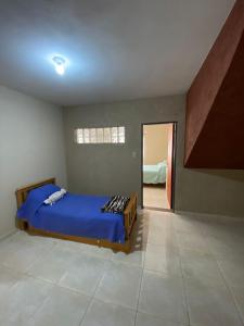 1 dormitorio con cama azul y espejo en Esquina Apart en Alta Gracia