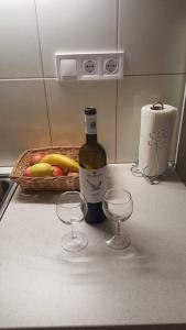 a bottle of wine and two wine glasses on a kitchen counter at Sugar House City Center Apartment in Budapest