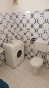 a bathroom with a washing machine and a toilet at Sugar House City Center Apartment in Budapest