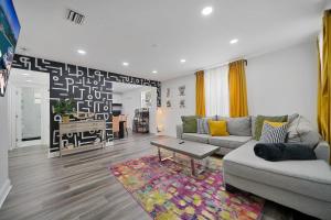 a living room with a couch and a table at Vacay Spot Wynwood Retreat 6 to 42 Guests 6 Kitchens Shower Massage jets, BBQ, Patio LED vibes, Prime LOC! 6 blocks away 4rm Bars, Nite Clubs, Res, Shops in Miami