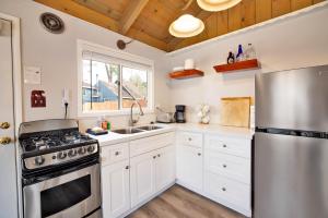 een keuken met witte kasten en een roestvrijstalen koelkast bij 2294-Storyville cabin in Big Bear Lake