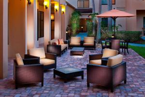 墨爾本的住宿－墨爾本西萬怡酒店，庭院配有桌椅和雨伞。