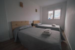 1 dormitorio con 2 camas y ventana en Laxiela Apartment en O Grove