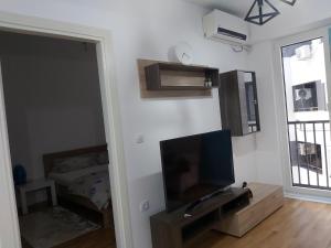 a living room with a television and a bedroom at Kosara in Skopje