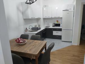 a kitchen with a wooden table and white appliances at Kosara in Skopje