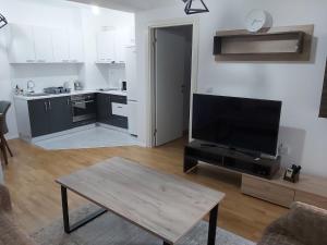 a living room with a flat screen tv and a table at Kosara in Skopje