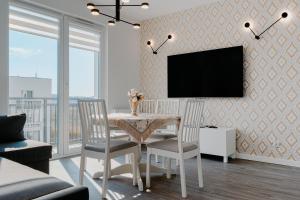 a dining room with a table and chairs and a tv at Jak u siebie w domu. Apartament w nowej dzielnicy. in Tczew