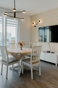 - une salle à manger avec une table, des chaises et une télévision dans l'établissement Jak u siebie w domu. Apartament w nowej dzielnicy., à Tczew