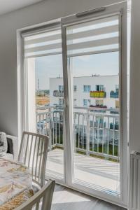 um quarto com uma varanda com portas de vidro deslizantes em Jak u siebie w domu. Apartament w nowej dzielnicy. em Tczew