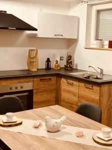 uma cozinha com uma mesa com um bule de chá em Gîte Cosy au cœur de l'Alsace em Roggenhouse