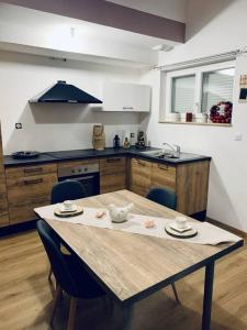 uma cozinha com uma mesa de madeira com cadeiras e uma cozinha em Gîte Cosy au cœur de l'Alsace em Roggenhouse