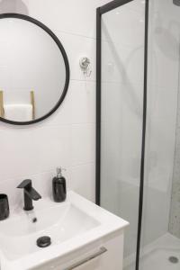 W łazience znajduje się biała umywalka i lustro. w obiekcie Apartament w centrum Mielca w Mielcu