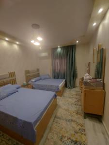 a bedroom with two beds and a window at شقه في جاردينيا الماظه تحتوى على ٣غرف مكيفه وريسبشن وحمام ومطبخ وريسبشن وبلكونه بجوار سنتر الماظه وسنتر سيتي ستارز الدور الثالث ولها موقع متميز وبلكونه تطل علي مول الكمبوند in Cairo