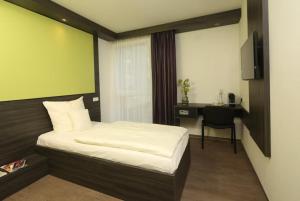 Habitación de hotel con cama y escritorio en GRG Kanha Inn Lucknow, en Lucknow