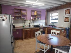 a kitchen with a wooden table and a refrigerator at Penelope Selfcatering Apartment in Wilderness