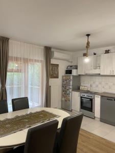 a kitchen with a table and chairs in a room at IKONIJA guest house in Pečenjevce