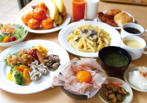 un tavolo di legno con piatti di cibo sopra di APA Hotel Haneda Anamori Inari Ekimae a Tokyo