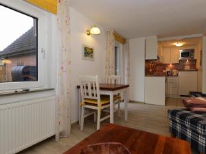 a living room with a table and a kitchen at Ferienwohnung in Wyk-Boldixum auf Foehr in Boldixum