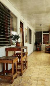 une terrasse couverte avec des bancs, une table et une plante dans l'établissement Casa I`X, à Quetzaltenango